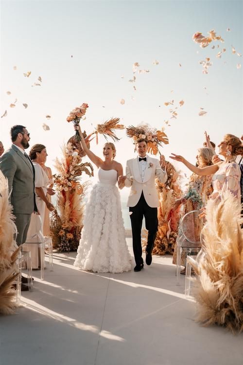 Civil Wedding Celebration A joyful couple walks hand in hand under a floral arch while guests throw petals into the air, celebrating their official legal wedding ceremony.