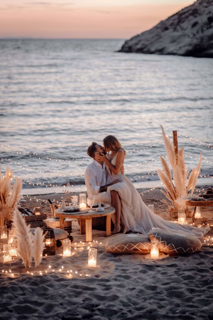 A romantic proposal setup by the sea in Crete, with a couple kissing among pillows, candles, and elegant decor — part of Celebrations and Events in Crete.