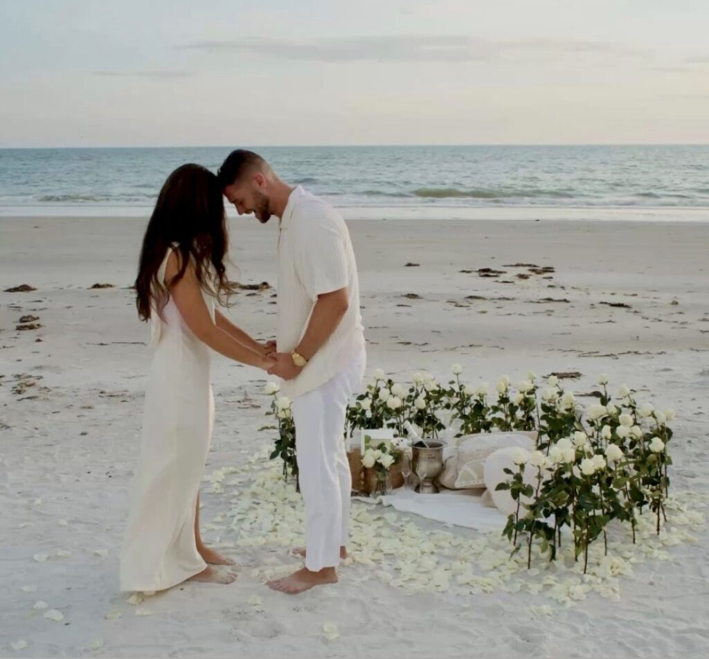 Romantic beach proposal setup with white roses in sunset Crete⁠