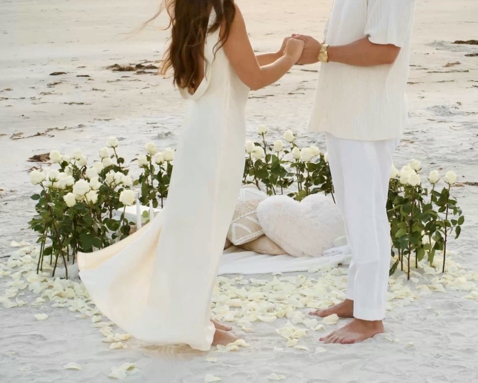 Romantic beach proposal setup with white roses and candles in Crete⁠