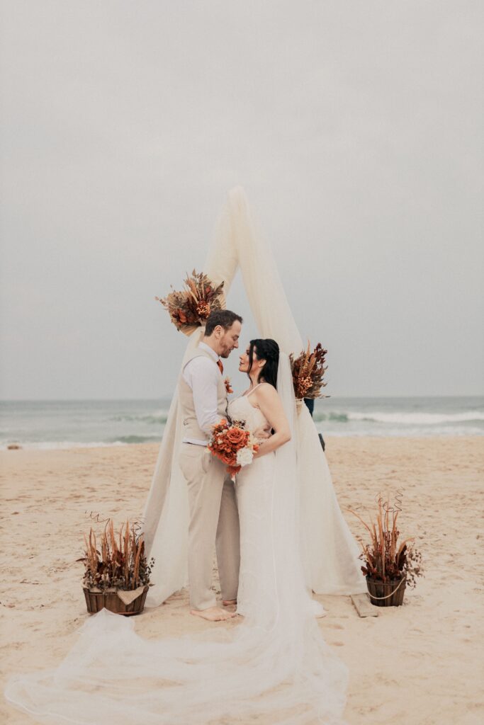 Boho-chic beach elopement setup in Crete featuring a floral arch and seaside view, styled by Wed-Space.