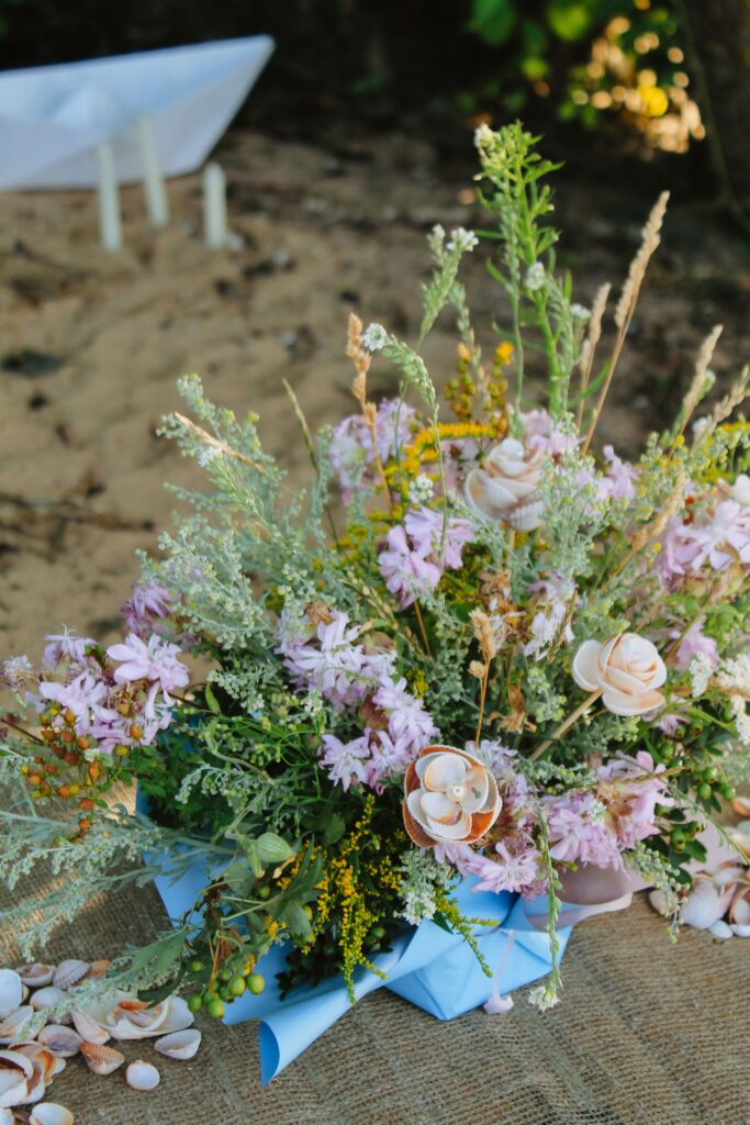 Detailed view of a wildflower wedding arrangement with lavender and seashells on a Cretan beach, curated by Wed-Space.